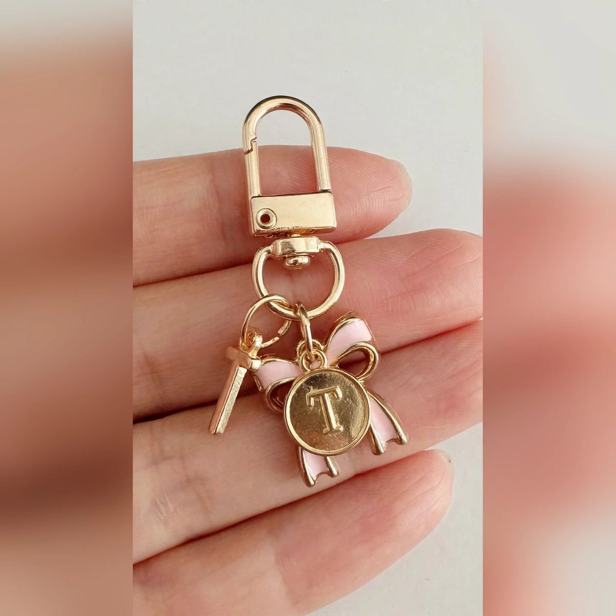 Bow Initial Bag Charm - Letter Charm T close-up held in hand