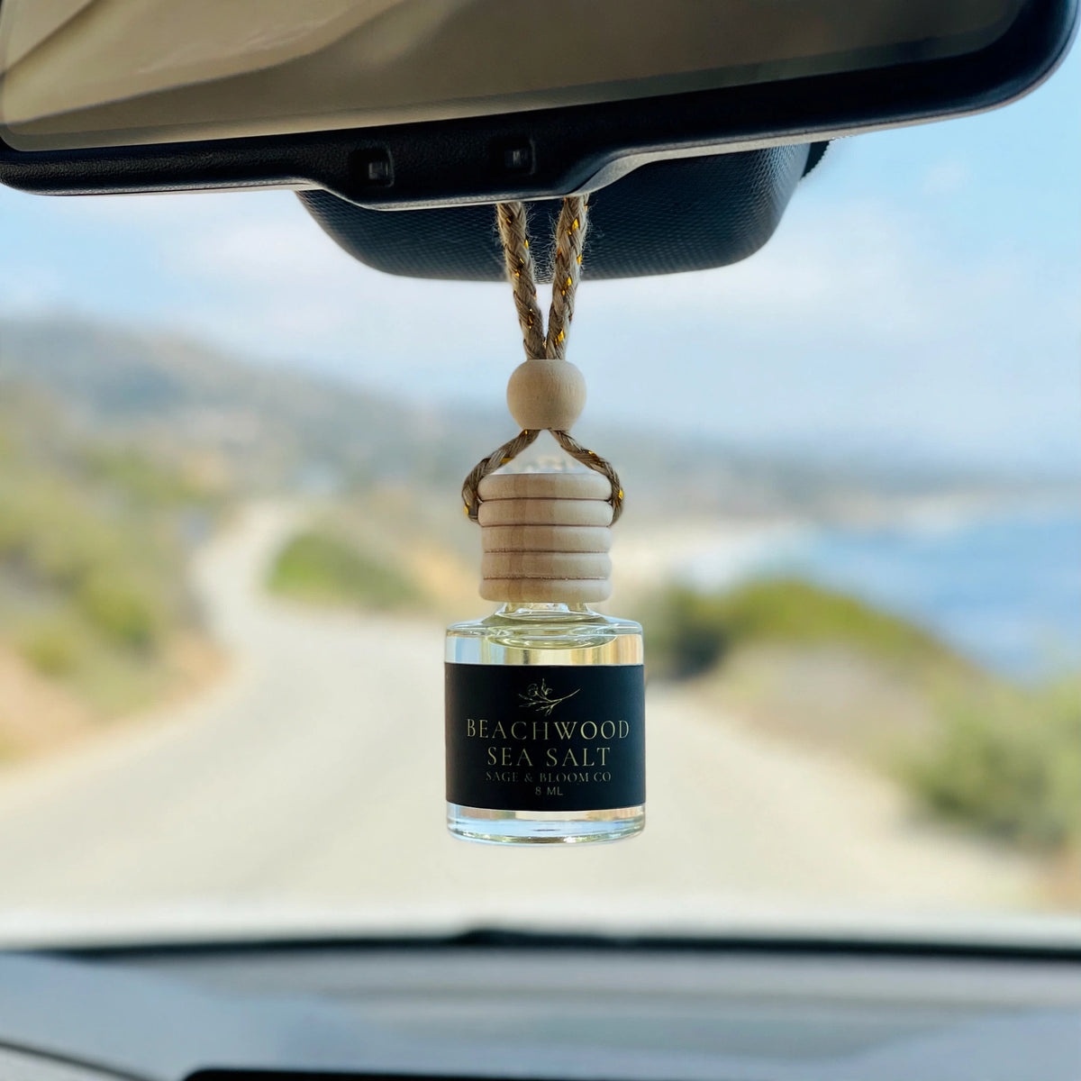 Beachwood Sea Salt car diffuser hanging from a rearview mirror on a coastal drive