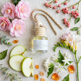 Camellia Patchouli Flower car diffuser flat lay with camellia, pink berries, apple and amber