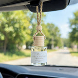 Citrus Blossom Woods car diffuser hanging from a rearview mirror on a summer drive