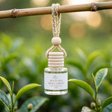Matcha Bergamot car diffuser hanging from bamboo in a tea garden