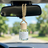 Magnolia Peony car diffuser hanging from a rearview mirror on a summer drive