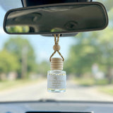 Oud Patchouli Resins car diffuser hanging behind the rearview mirror on a summer drive