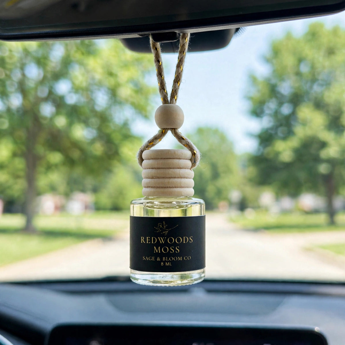 Redwoods Moss car diffuser hanging behind the rearview mirror on a summer drive