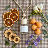 Gingham car diffuser flatlay with scent-note props