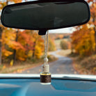 Bourbon Apples car diffuser hanging in car with fall landscape