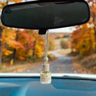 Cozy Flannel car diffuser hanging in car with fall landscape