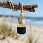 Beachwood Sea Salt car diffuser hanging from driftwood at the beach