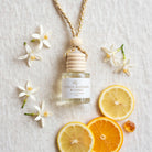 Citrus Blossom Woods car diffuser flat lay with citrus, orange blossoms and jasmine
