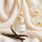 Cashmere Vanilla car diffuser against draped rich cashmere with vanilla orchid and vanilla beans