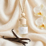 Cashmere Vanilla car diffuser against draped rich cashmere with vanilla orchid and vanilla beans
