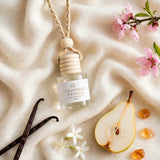 Cashmere Vanilla car diffuser flat lay on rich cashmere with vanilla beans, pear, jasmine and amber