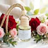 Dark Rose Vanilla car diffuser styled among deep red and blush roses