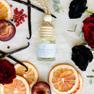 Dark Rose Vanilla car diffuser flat lay with black roses, pink peppercorn, grapefruit, plum and vanilla