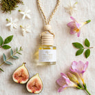 Fig Tree Freesia car diffuser flat lay with figs, freesia, jasmine, leaves and moss
