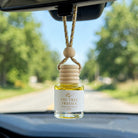 Fig Tree Freesia car diffuser hanging from a rearview mirror on a summer drive