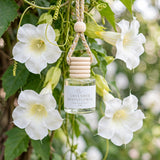 Lavender Moonflower car diffuser hanging among white moonflower blossoms