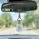 Oud Patchouli Resins car diffuser hanging behind the rearview mirror on a summer drive