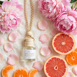 Pink Peony Grapefruit car diffuser flat lay with fluffy pink peonies, grapefruit and mandarins