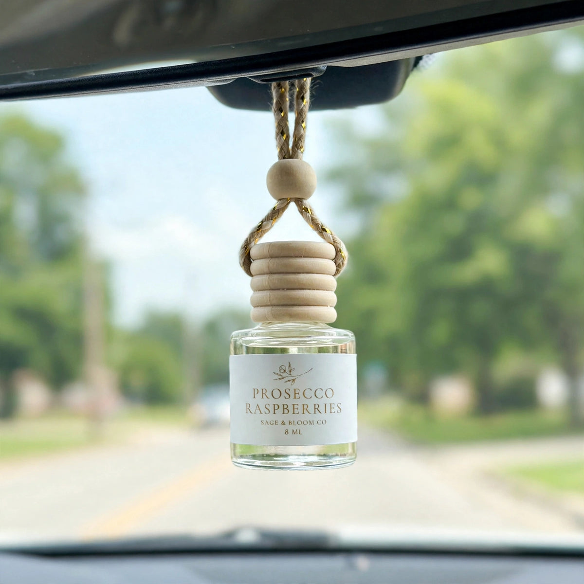 Prosecco Raspberries car diffuser hanging behind the rearview mirror on a summer drive