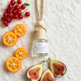 Red Currant Kumquat car diffuser flat lay with red currants, kumquats and fig