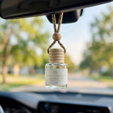 Red Currant Kumquat car diffuser hanging behind the rearview mirror on a summer drive