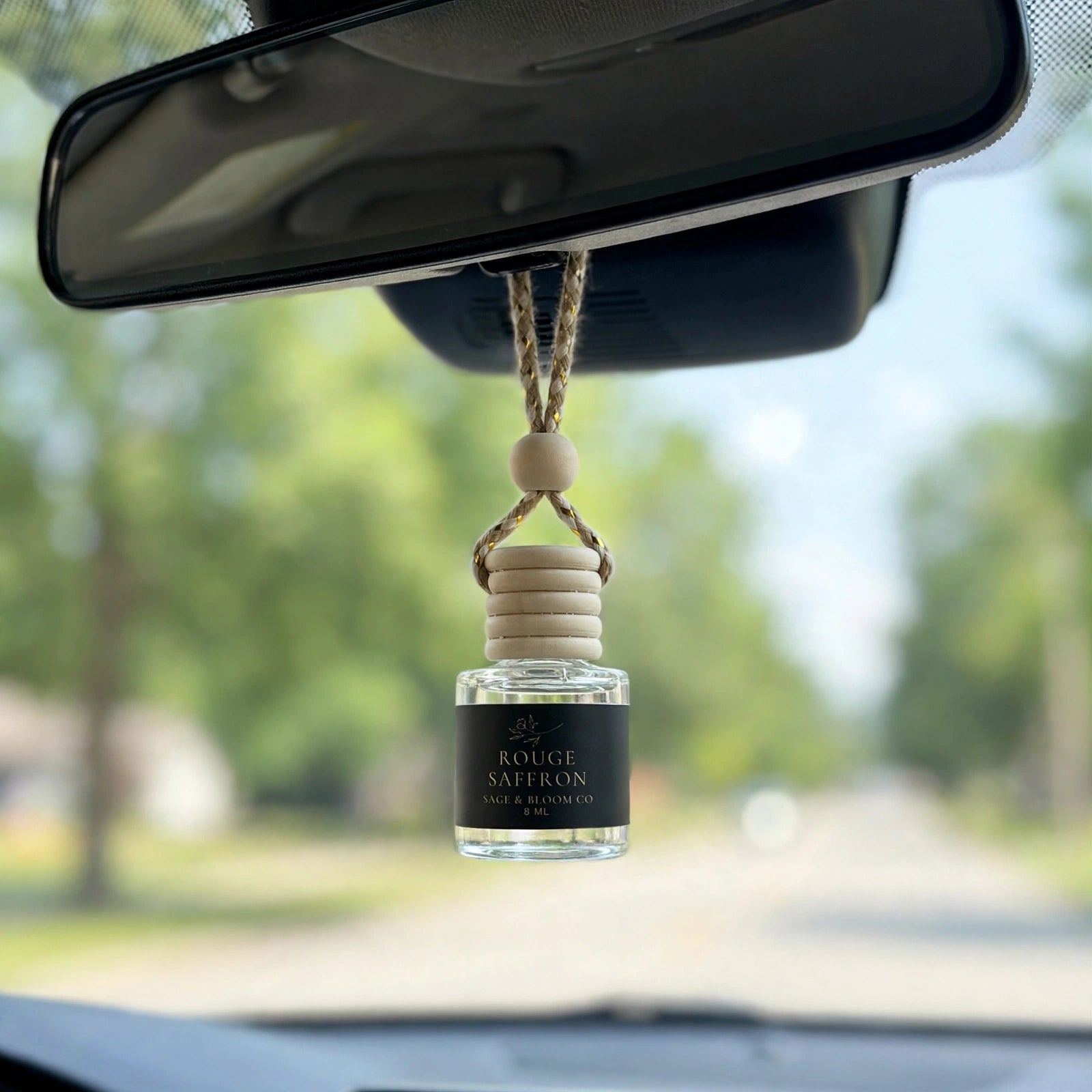Rouge Saffron car diffuser hanging behind the rearview mirror on a summer drive