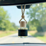 Saffron Tobacco car diffuser hanging behind the rearview mirror on a summer drive