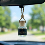 Tonka Sandalwood car diffuser hanging behind the rearview mirror on a summer drive