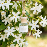 White Tea Jasmine car diffuser hanging among white jasmine blossoms