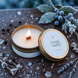 Lit Nordic Nights travel tin candle with wooden wick on frosted walnut