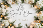 Sage and Bloom Co gift card in a holiday design with white roses, hydrangeas, evergreen, gold ornaments and candlelight