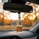 Vanilla Pumpkin Santal car diffuser at golden hour with fall trees